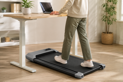 Person walking on the Understride pad under a standing desk while working on a laptop